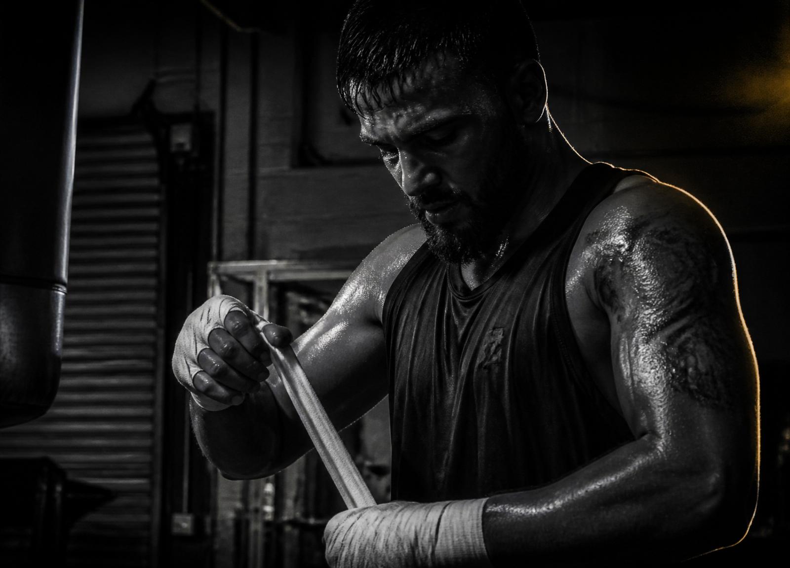 Atleta da Selva Boxe enrolando bandagem antes do treino em Osasco